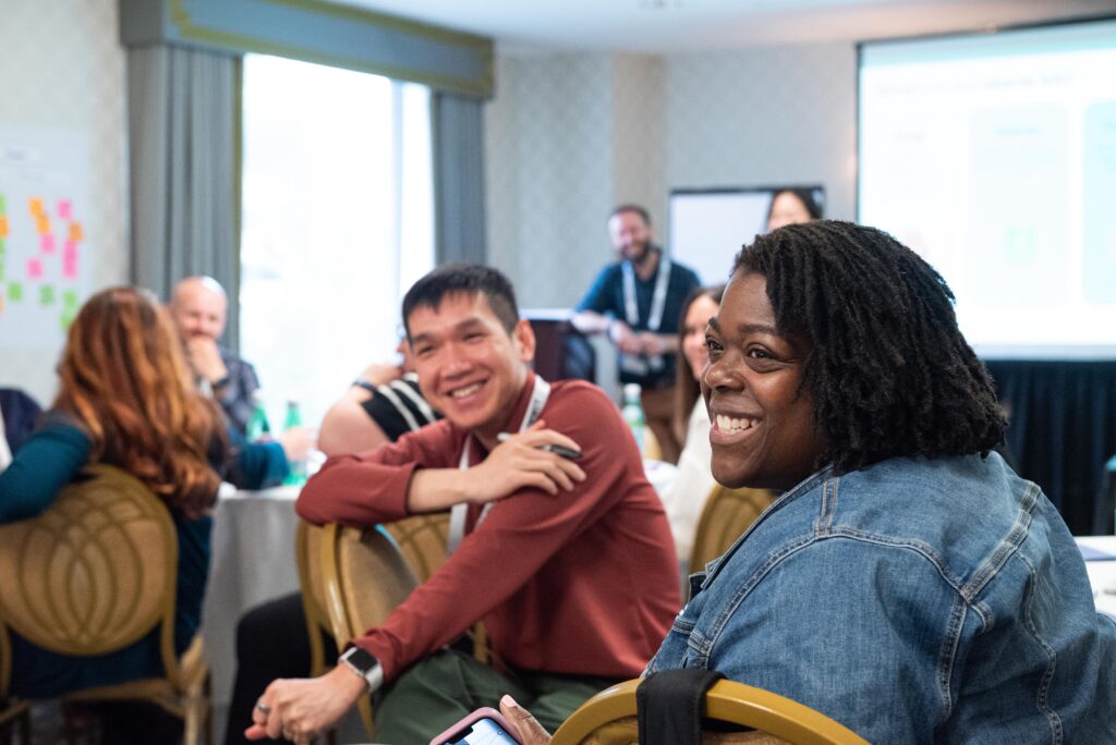 Workshop attendees smiling in a Code for America Summit breakout session