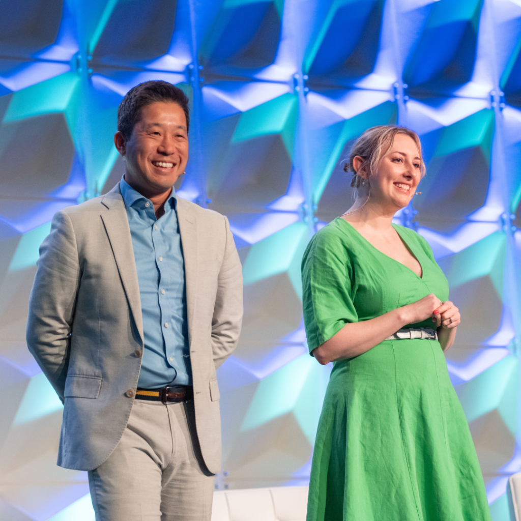 Two people on stage at Code for America Summit, both smiling